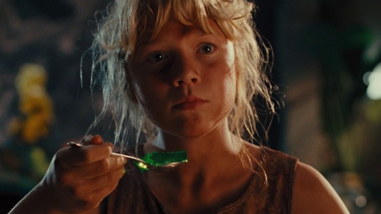 Ariana Richards as Lex Murphy in Jurassic Park, holding a spoonful of jello while looking at something.
