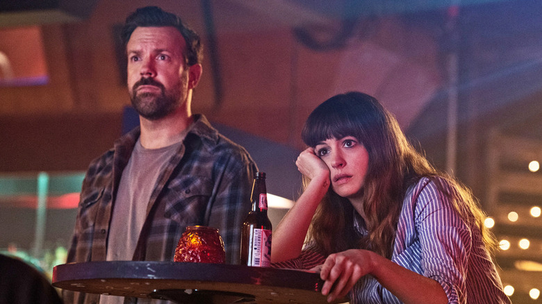 Jason Sudeikis as Oscar and Anne Hathaway as Gloria, watching a bar TV in Colossal.