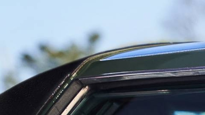 Slick Charles (Jamie Foxx), Yo-Yo (Teyonah Parris), and Fontaine (John Boyega) inside a green car in They Cloned Tyrone