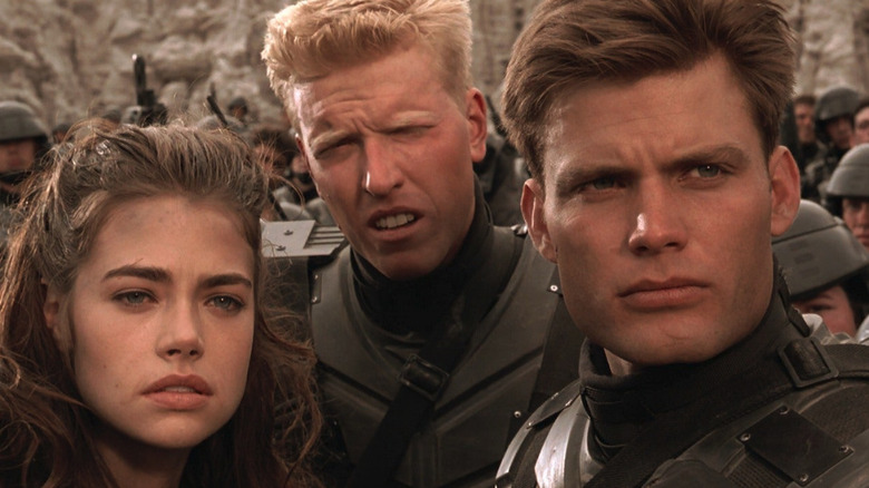 Denise Richards as Carmen, Jake Busey as Ace, and Casper Van Dien as Johnny on the battlefild in Starship Troopers