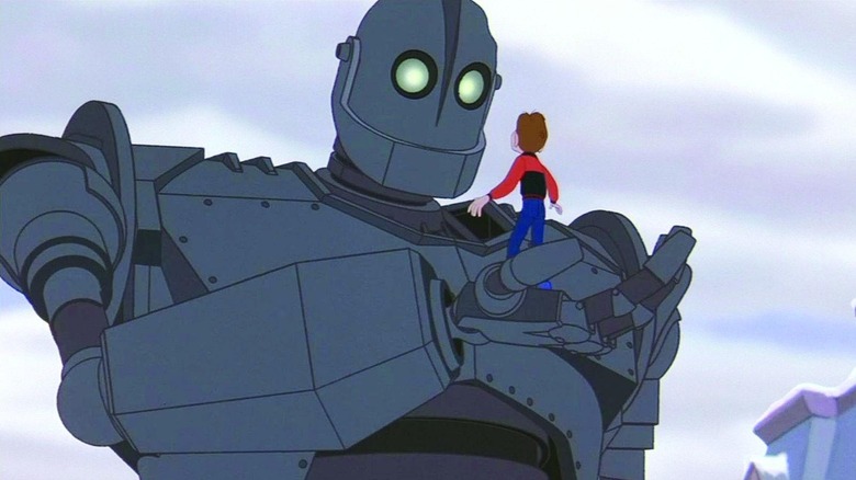 Vin Diesel as the iron giant, holding Eli Marienthal as Hogarth, in his hand in The Iron Giant