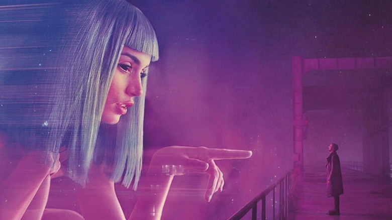 Ana de Armas as Joi pointing at Ryan Gosling as K, in Blade Runner 2049