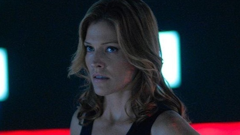 Number Six (Tricia Helfer) stands in a dimly lit room in Battlestar Galactica