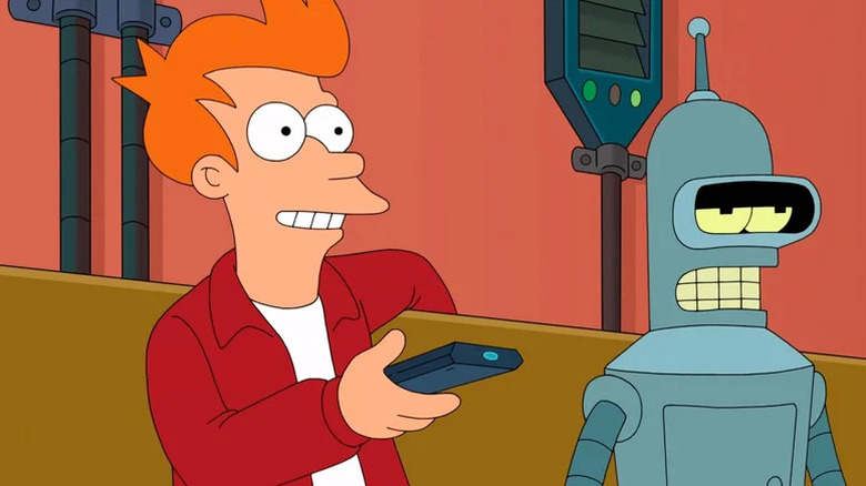 Philip J. Fry (Billy West) uses a remote control while sitting with Bender (John DiMaggio) on a couch in Futurama