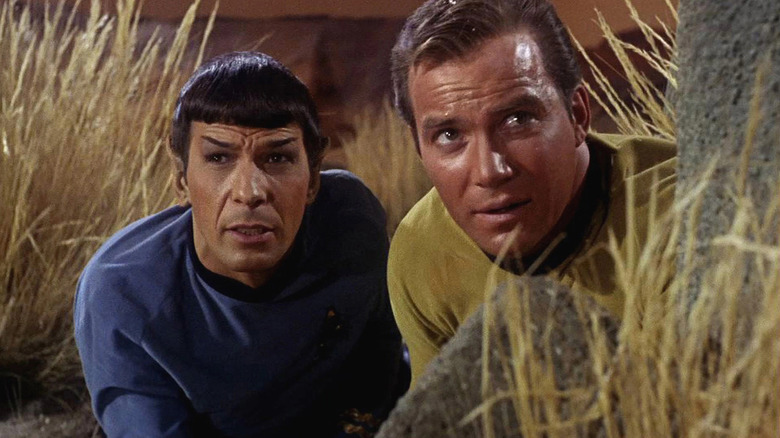 Spock (Leonard Nimoy) and Kirk (William Shatner) take cover behind a rock in Star Trek: The Original Series