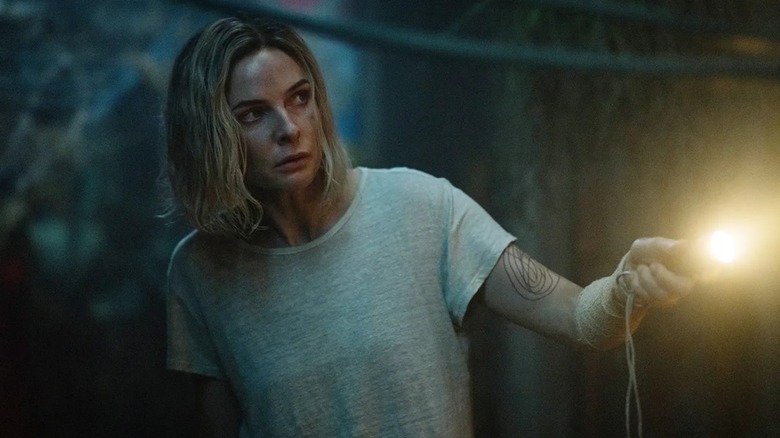 Juliette (Rebecca Ferguson) investigates the gloom wtith a flashlight on Silo