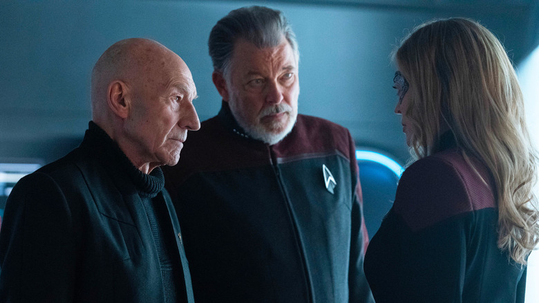 Patrick Stewart as Jean-Luc Picard, Jonathan Frakes as Will Riker, and Jeri Ryan as Seven of Nine, speaking to each other in in Star Trek: Picard.