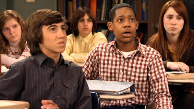 Vincent Martella as Greg Wuliger sits next to Tyler James Williams as Chris in the classroom on Everybody Hates Chris
