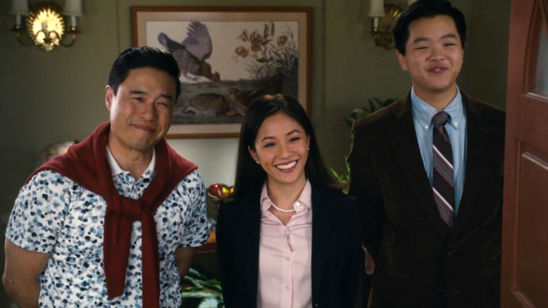 Randall Park as Louis Huang stands in a doorway next to Constance Wu as Jessica Huang and Hudson Yang as Eddie Huang on Fresh Off the Boat