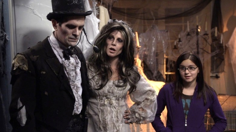 Ty Burrell as Phil Dunphy and Julie Bowen as Claire Dunphy wear Halloween costumes while standing next to Ariel Winter as Alex Dunphy on Modern Family
