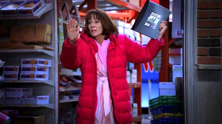 Patricia Heaton as Frankie Heck stands in a store with a folder in her hands on The Middle