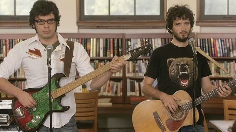 Jemaine Clement and Bret McKenzie as fictional versions of themselves playing a gig in a library in Flight of the Conchords
