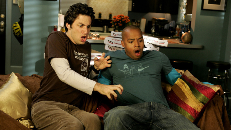 Zach Braff and Donals Faison as JD and Turk are shocked by something on their couch in Scrubs