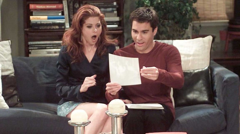 Debra Messing and Eric McCormack as Grace Adler and Will Truman reading a sheet of paper in Will & Grace