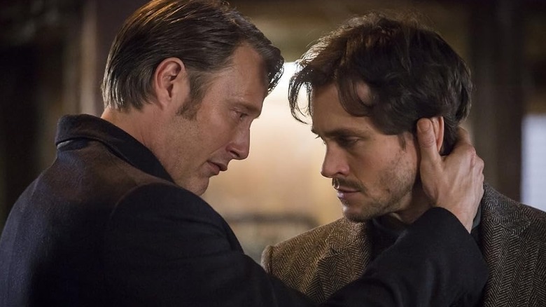 Mads Mikkelsen as Dr. Hannibal Lecter and Hugh Dancy as Will Graham, moving their heads close to one another in Hannibal.