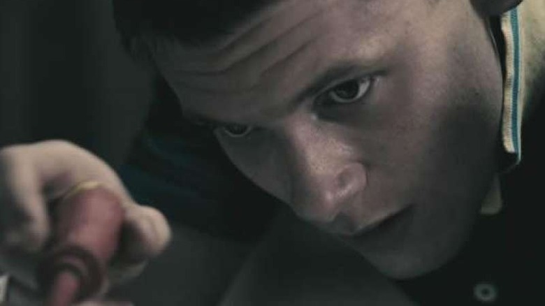 Jack O'Connell as Kurtis, fixing something in Tower Block