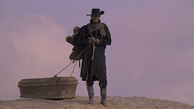 Franco Nero as Django, dragging a coffin in Django