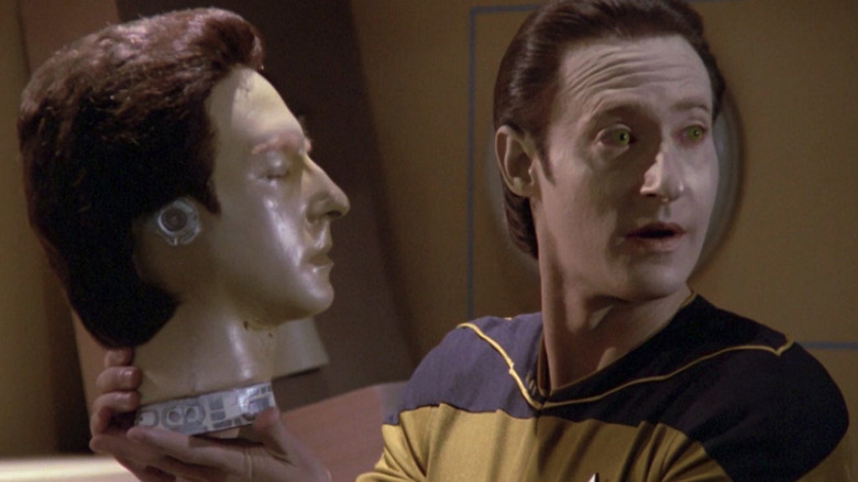 Data (Brent Spiner) stands with a duplicate head of himself in Star Trek: The Next Generation