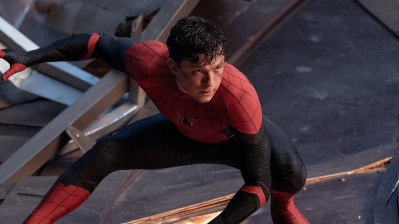 Tom Holland in a classic athletic pose as an unmasked Peter Parker in Spider-Man: No Way Home.