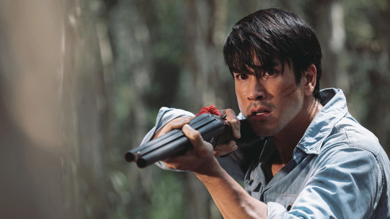 Nadech Kugimiya as Yak, shotting demons in Death Whisperer 2