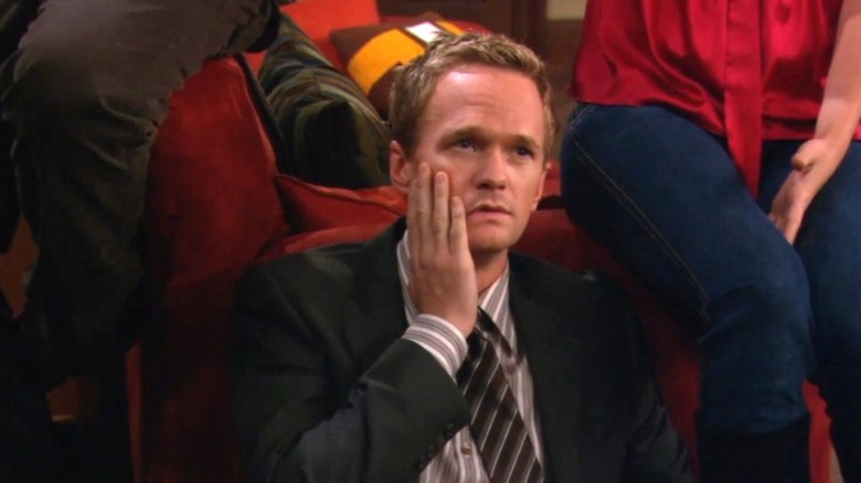 Neil Patrick Harris as Barney Stinson touching his face with his right hand on How I Met Your Mother