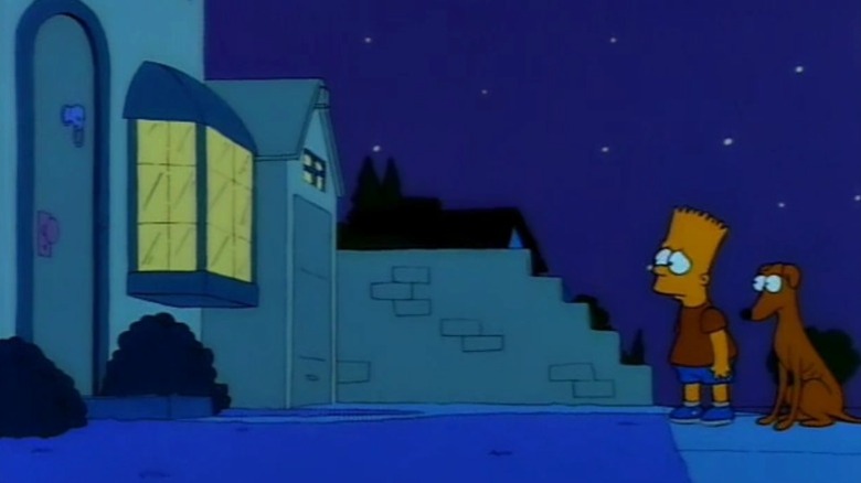 Bart Simpson standing anxiously in front of his house at night with Santa's Little Helper by his side on The Simpsons