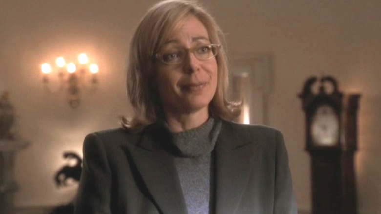 Allison Janney as C.J. Cregg smiling skeptically on The West Wing