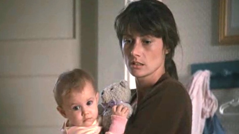 Mel Harris as Hope Steadman holding her baby and looking down with a melancholy expression on Thirtysomething