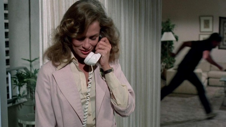 Leigh Michaels (Lauren Hutton) speaks on a phone while a shadowy stalker moves in the background in Someone's Watching Me!