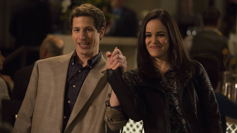 Andy Samberg as Jake and Melissa Fumero as Amy holding hands in Brooklyn Nine-Nine