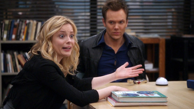 Gillian Jacobs as Britta and Joel McHale as Jeff sitting at the study table together in Community