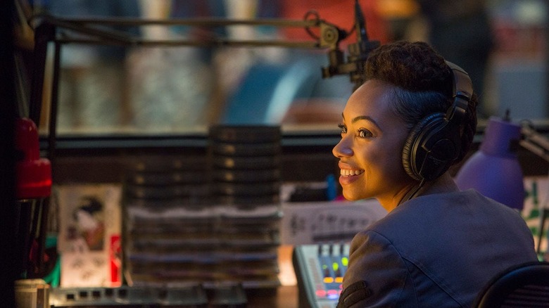 Logan Browning as Sam smiling and wearing headphones in Dear White People
