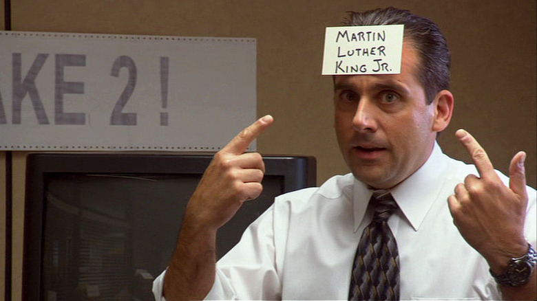 Steve Carell as Michael Scott wearing a notecard that says "Martin Luther King Jr." in The Office