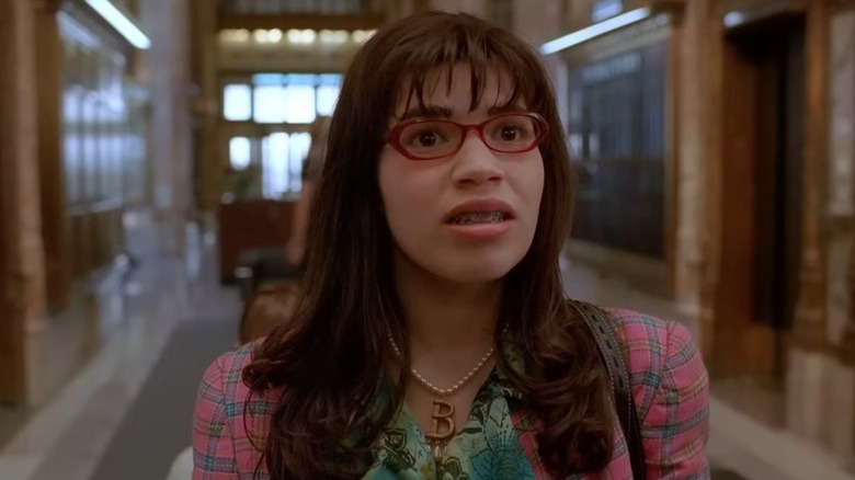 America Ferrera as Betty Suarez standing in a corridor with a confused expression on Ugly Betty