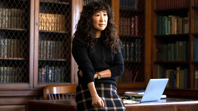 Sandra Oh as Ji-Yoon Kim stands in front of her desk in The Chair
