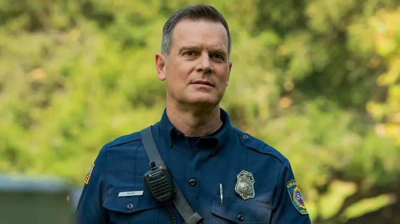 Peter Krause as Bobby Nash, standing near trees on 9-1-1