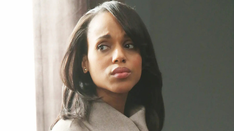 Kerry Washington as Olivia Pope, standing by a window anxiously on Scandal