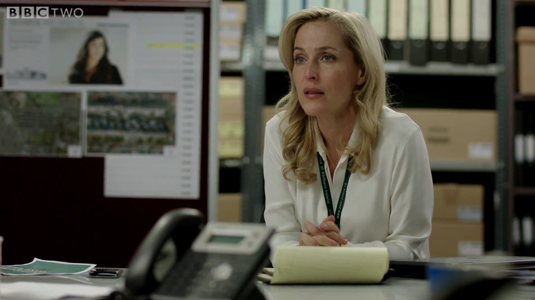 Gillian Anderson as Stella Gibson sitting in brightly-lit police station in The Fall