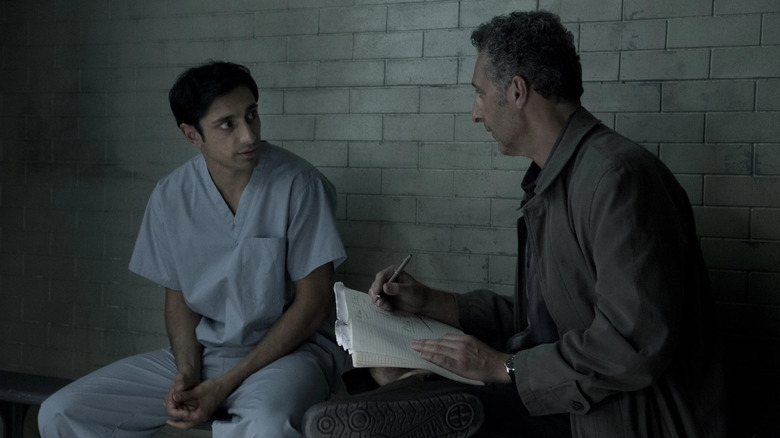 Naz Khan (Riz Ahmed) sits in his prison cell with John Stone (Jon Turturro) as he takes notes in The Night Of