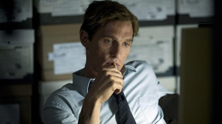 A moody Rust Cohle (Matthew McConaughey) puts a cigarette in his mouth in True Detective