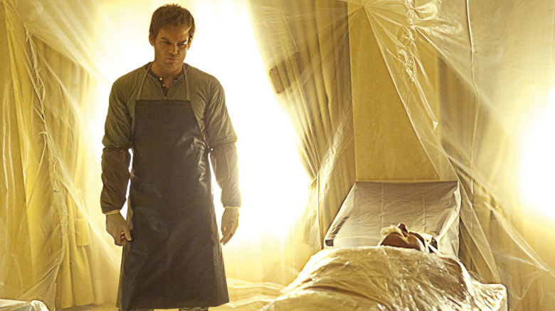 Dexter Morgan (Michael C. Hall) stands solemnly by a body in a room covered in plastic on Dexter