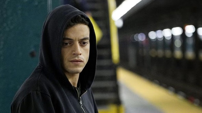 Elliot Alderson (Rami Malek) stands downcast in a New York subway station in Mr. Robot