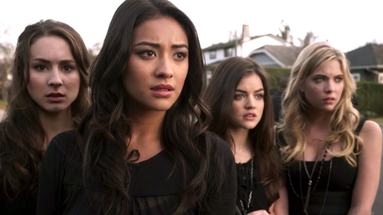Spencer Hastings (Troian Bellisario), Emily Fields (Shay Mitchell), Aria Montgomery (Lucy Hale), and Hanna Marin (Ashley Benson) stand in shock outside on Pretty Little Liars (2010)