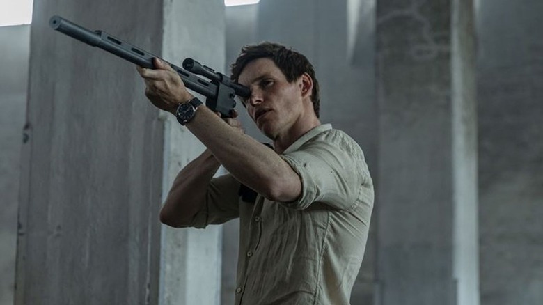 The Jackal (Eddie Redmayne) aims a sniper rifle in The Day of the Jackal