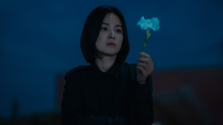 Moon Dong-eun (Song Hye-kyo) holds a flower in The Glory
