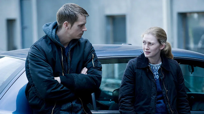 Stephen Holder (Joel Kinnaman) and Sarah Linden (Mireille Enos) speak to each other by a parked car on The Killing (2011)
