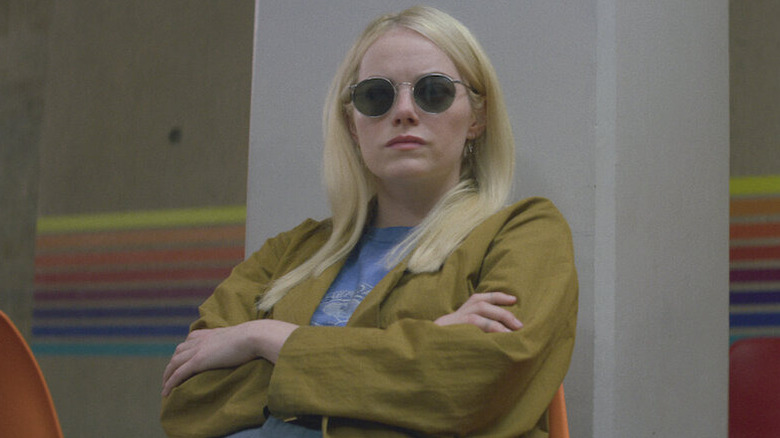 Emma Stone as Annie sitting with sunglasses in Maniac