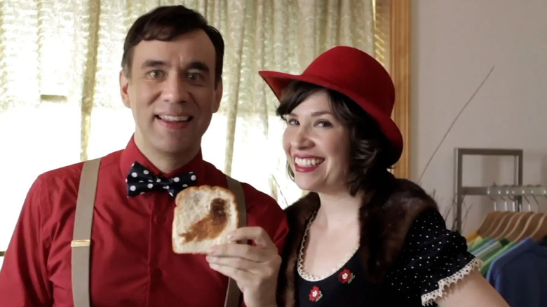 Fred Armisen and Carrie Brownstein smiling and holding toast with a bird on it in Portlandia