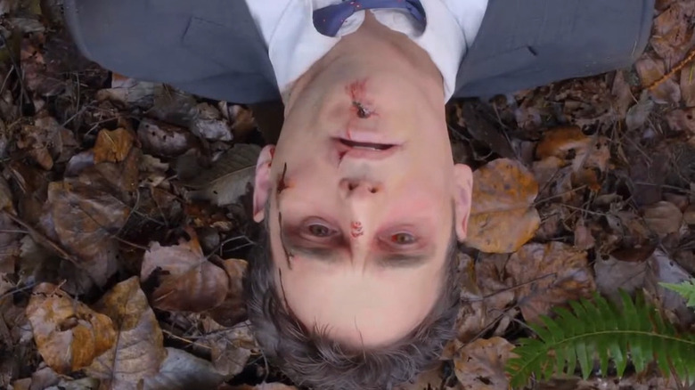Ethan Burke (Matt Dillon) lying on leaves bloodied on Wayward Pines