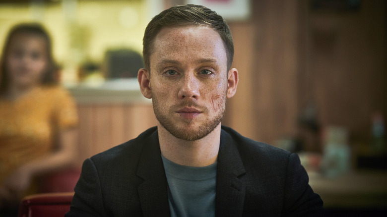 Sean Wallace (Joe Cole) sits stoically looking ahead in Gangs of London